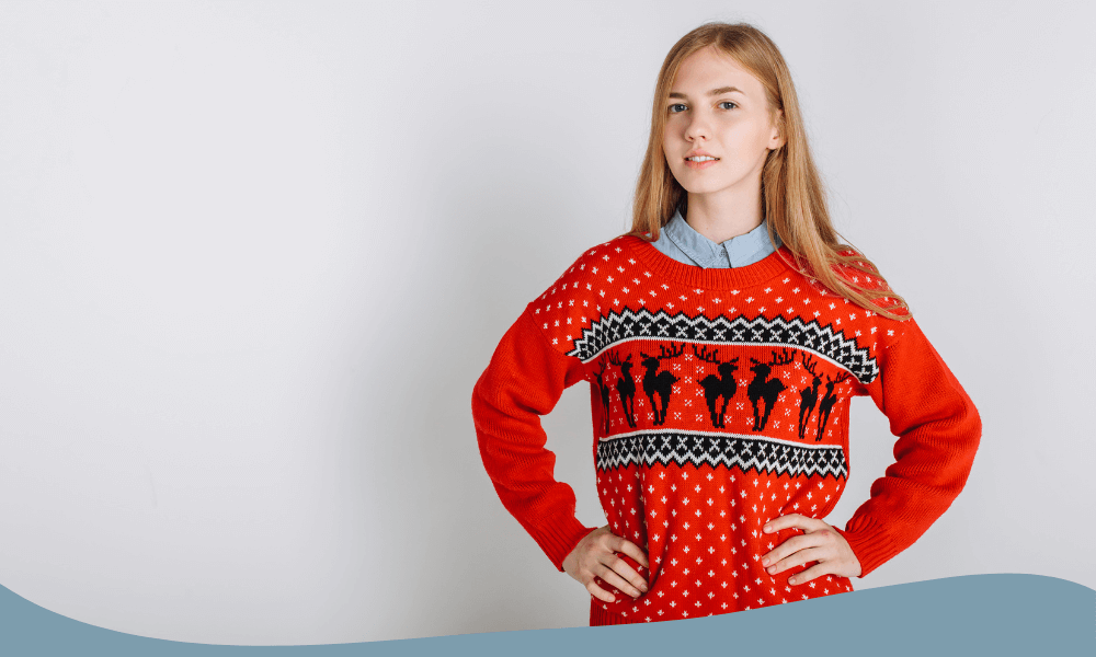 Klassisk röd jultröja med renmotiv och snöflingor i traditionellt stickat mönster