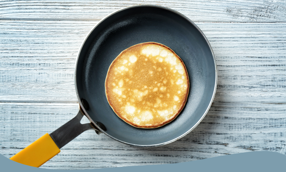 Färdiggräddad pannkaka i en non-stick pannkakspanna med gult handtag