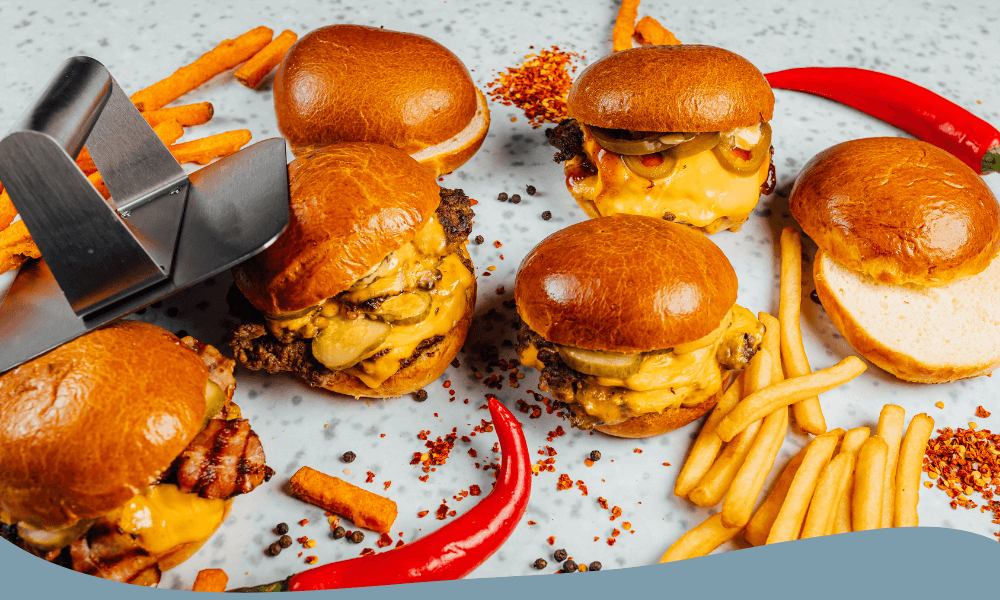 Smashburgare med cheddarost och bröd serverade med pommes och chili för extra smak