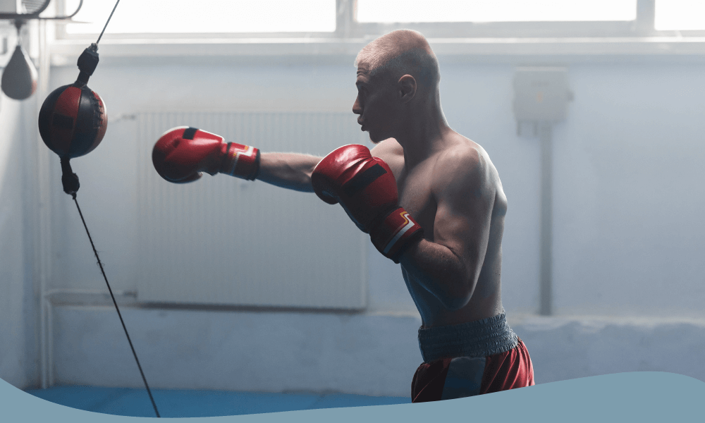 Man tränar boxning med en boxboll för reflex och snabbhet i gymmiljö.