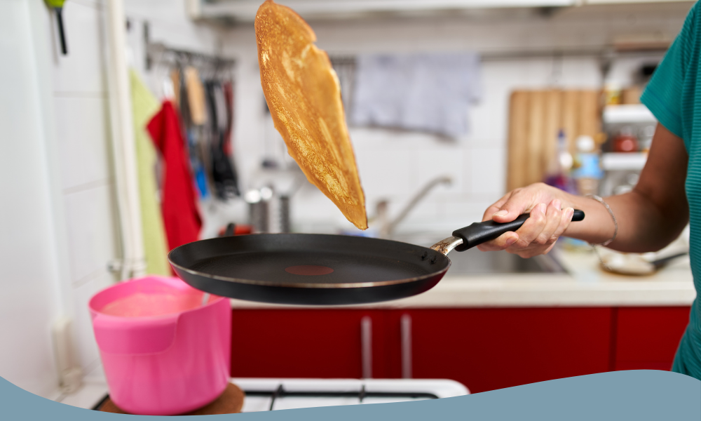 Person vänder en pannkaka i non-stick panna i köket