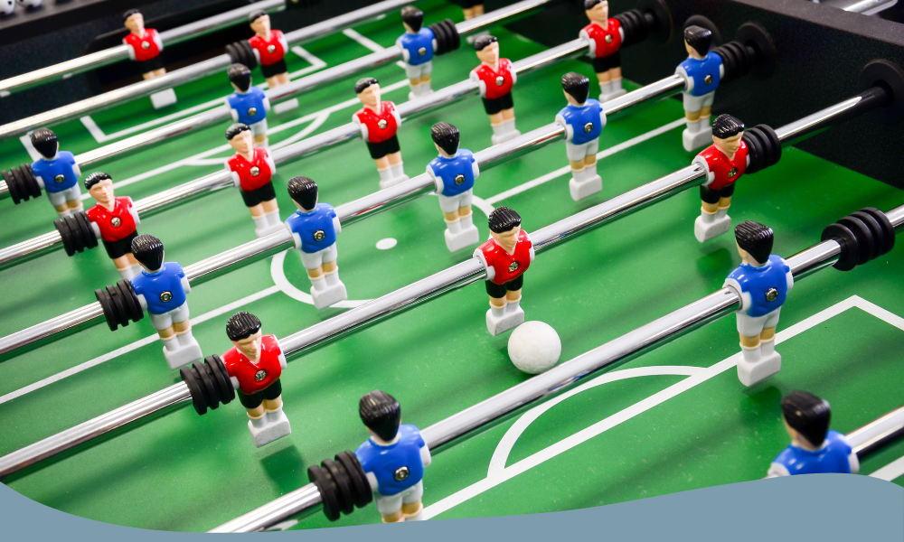 Närbild på fotbollsspel med röda och blåa spelare, redo för action på spelplanen.
