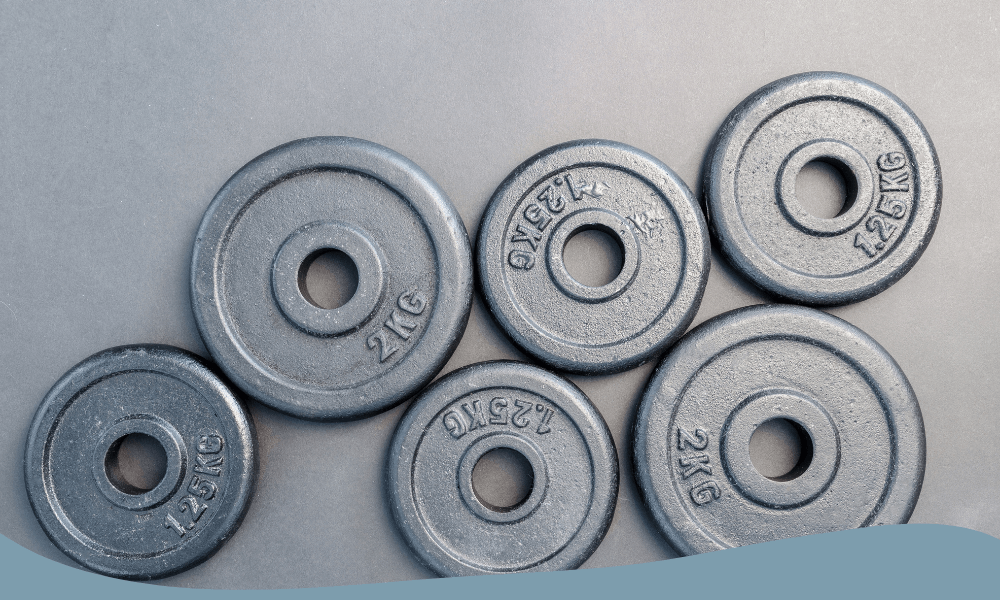Olika gjutjärnsskivor i 1,25 till 2,5 kg utspridda för hemmagym och styrketräning.