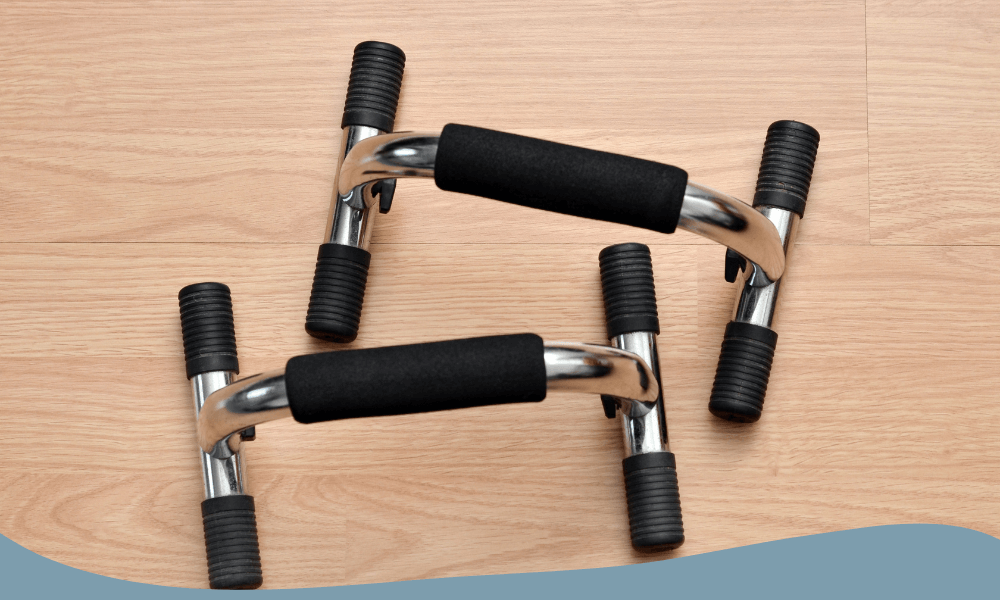 Push up bars i krom på trägolv med greppvänliga skumhandtag