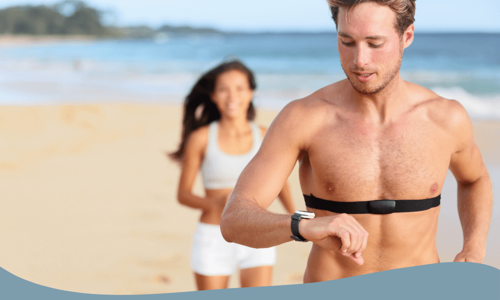 Man springer med pulsband och pulsklocka på stranden – tränar med pulszon för optimal effekt.