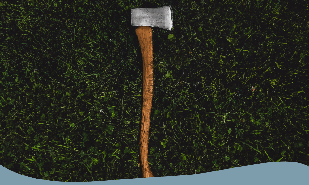 Lång friluftsyxa med böjt trähandtag och robust egg, perfekt för vedhuggning i skogsmiljö.