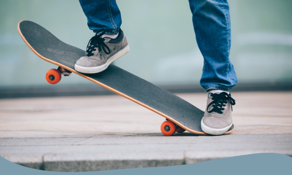 Skateboardåkare tränar trick på svart skateboard med orange hjul